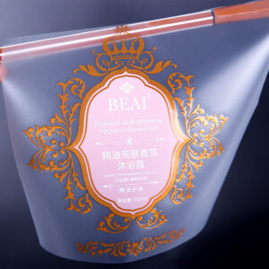 Luxury transparent cosmetic label applied on shower gel pouch with ornate metallic style frame and soft pink center panel
