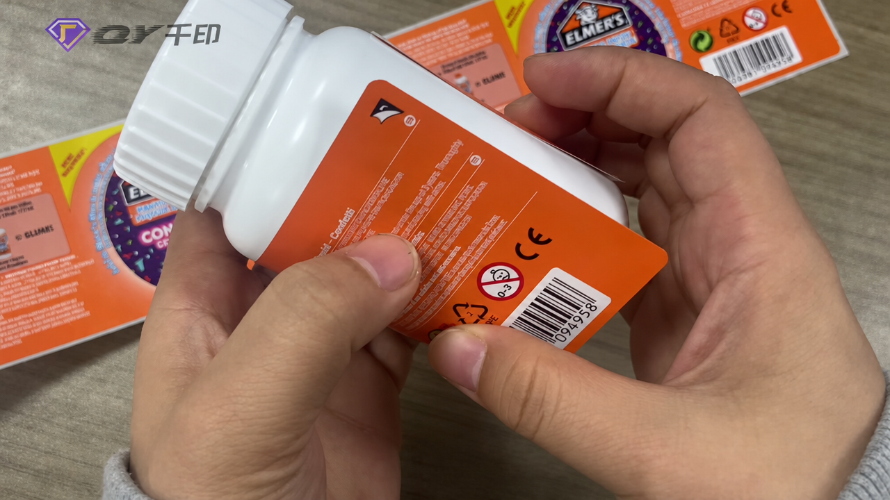 Real multi-layer label footage showing a bottle and opened label panels